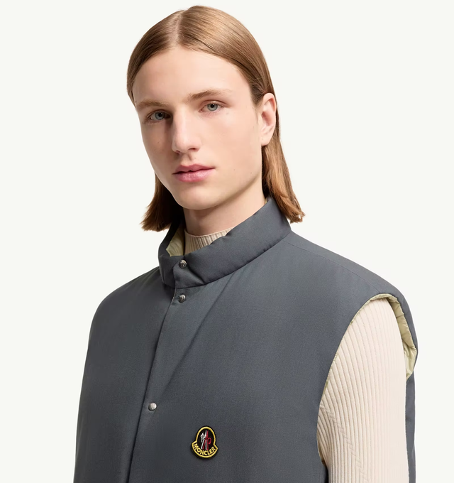 Image 2 of 2 - GREEN - Moncler Men's Tibb Reversible Down Vest is crafted from water-repellent longue saison nylon and features a reversible oversized silhouette with a wool reverse side. A modern evolution of a Moncler icon, this down-filled vest is designed with a stand collar, snap-button front closure, zipped pockets, and a drawstring hem for an adjustable fit. Finished with a vintage-inspired metal logo, the versatile style transitions easily between layering options and changing conditions. Main Mater 