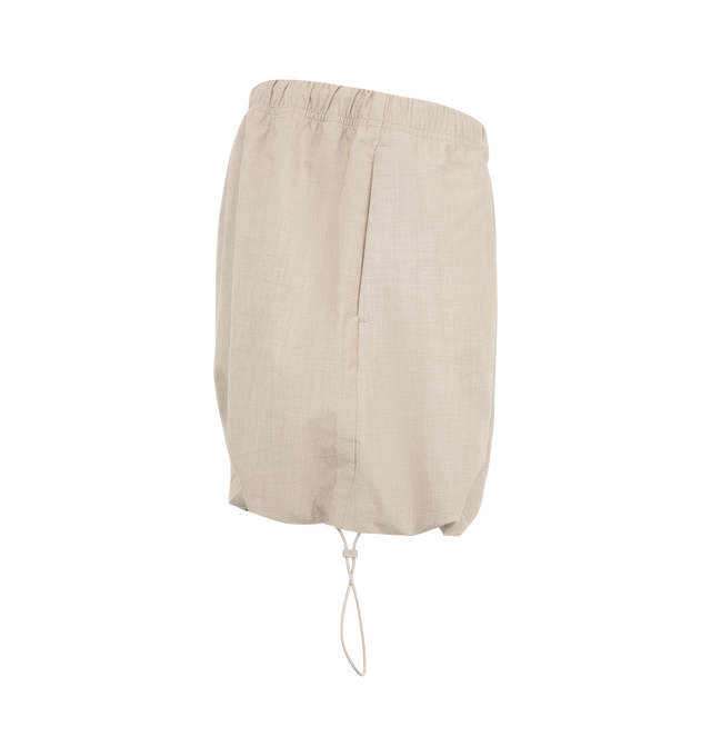 Image 3 of 3 - NEUTRAL - The Fear Of God Essentials Women's Micro Skirt is crafted from a silk stretch blend for elevated comfort. This mini silhouette features an encased elastic waistband with bungee drawcords and adjustable toggles at the waist and hem. Materials: 69% Polyester, 19% Silk, 8% Wool, 4% Spandex. 