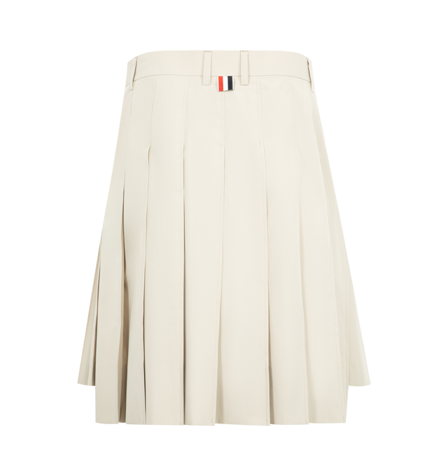 Image 2 of 3 - WHITE - THOM BROWNE Cotton Suiting Pleated Skirt featuring bermuda length, tab closure with zip fly, slip hand pockets with RWB grosgrain trim, side vents with RWB grosgrain trim, stepped hem and signature striped grosgrain loop tab. 100% cotton. Made in Italy. 