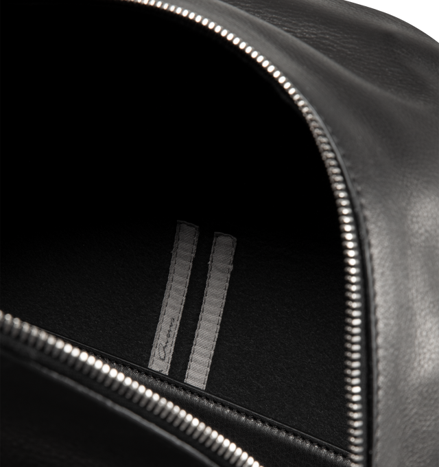 Image 3 of 3 - BLACK - RICK OWENS Leather Backpack featuring LWG-certified pebble-grained calfskin, rolled carry handle, adjustable padded shoulder straps, logo embossed at face, two-way zip pocket, D-ring at side, two-way zip closure, padded laptop compartment at interior and grained leather lining. H17" x W12" x D8". 100% calfskin. Made in Italy. 