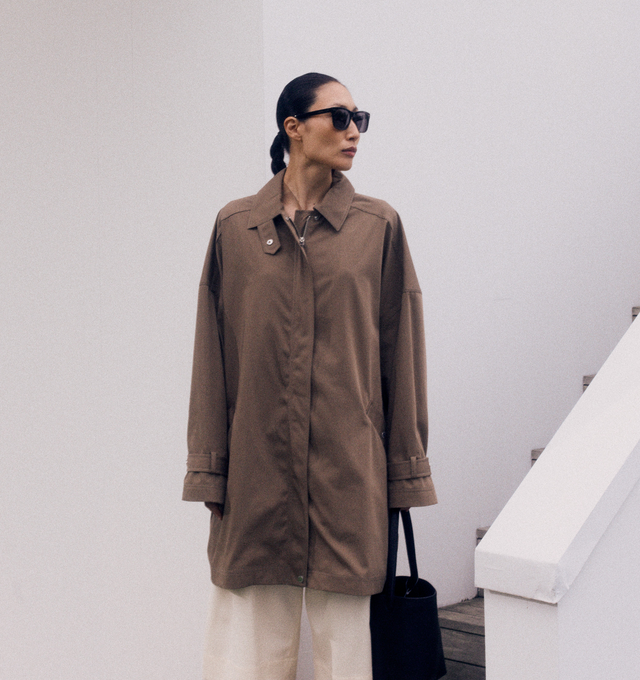 Image 2 of 4 - BROWN - TOTEME Oversized Trench Jacket with subtle trench coat accents featuring relaxed A-line silhouette, slanted pockets, adjustable cuff belts, a zipped front and snap buttons. 100% cotton organic. 