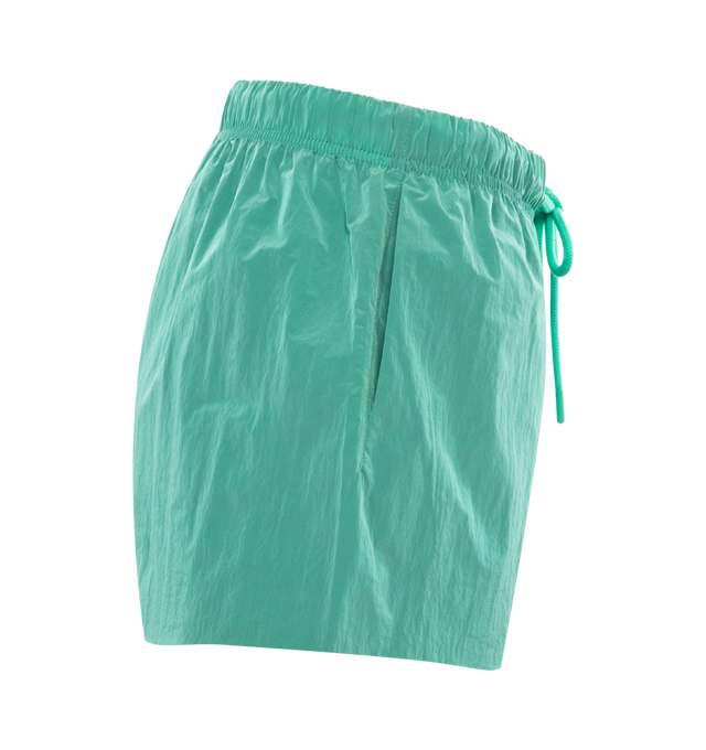 Image 3 of 3 - GREEN - FEAR OF GOD ESSENTIALS Crinkle Nylon Running Shorts featuring a relaxed fit, lightweight crinkle nylon construction, a rubber brand label on the front, side hand pockets, and an adjustable drawstring waistband. 100% nylon. 