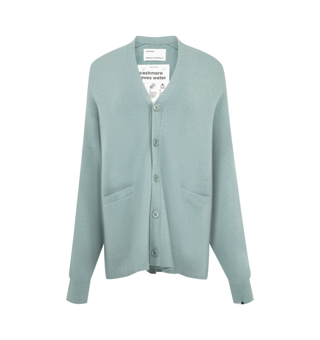 Image 1 of 2 - GREEN - Extreme Cashmere Women's N24 Tokio Cardigan Sweater is crafted from a premium cashmere blend and features a relaxed silhouette with dropped shoulders, two front patch pockets, and a unique side button that allows for adjustable styling. This designer cashmere cardigan combines exceptional softness with versatile functionality, while durable natural corozo buttons add a refined finishing touch. Main Material: 88% Cashmere, 10% Nylon, 2% Elastane. 