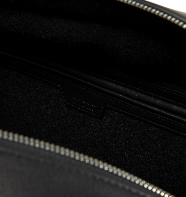 Image 3 of 3 - BLACK - The Row India Travel Bag is crafted from heavyweight felted wool and features a structured travel silhouette with tubular leather handles, smooth calfskin trim, and a zip-top closure. Designed to balance tactile warmth with polished sophistication, this elevated carryall is finished with a branded metal padlock and key, while the compact felted wool construction showcases a subtle mlange texture unique to natural materials. Main Material: 80% Virgin Wool, 20% Calfskin Leather. Lining: 