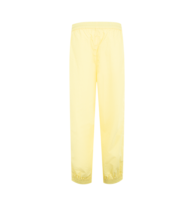 Image 2 of 3 - YELLOW - WILLY CHAVARRIA Bad Boy Track Pant featuring a relaxed, easy fit, side pockets, elastic waistband and hems, lightweight, stacked double CHAVARRIA logos at the left pocket and double stripes down legs. 100% nylon. 