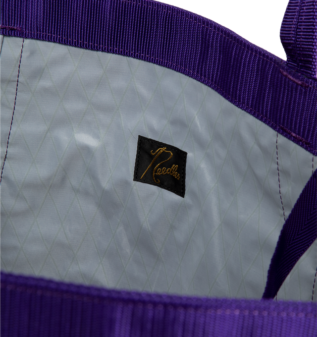 Image 3 of 3 - PURPLE - Needles Large Tool Tote is crafted from nylon and features a diamond-quilted construction, a Papillon print at the front, two top handles, grosgrain trim, a front slip pocket, and a zip-fastening back pocket. Designed as a spacious everyday carryall, this oversized tote offers ample room for work, travel, or daily essentials. Main Material: 100% Nylon. Dimensions: 76 x 32 x 33 cm / 29.9 x 12.6 x 13.0 in. Pockets: Front Open Pocket, Front Slip Pocket, Back Zip Pocket. Fits a 16" lapt 