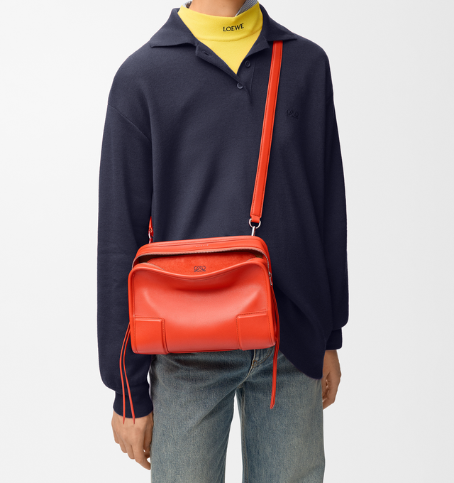 Image 4 of 17 - ORANGE - Loewe Small Amazona 180 Bag in leather features a relaxed silhouette anchored by a single toron top handle, designed to be carried open, while a concealed closure secures the main compartment, three carry options: short handle, removable shoulder strap and crossbody, zip closure with two leather zip pullers, two compartments, main compartment closed with magnetic closure, internal flat pocket, left side d-ring for customization, nappa lambskin lining, and embossed double L branding. 