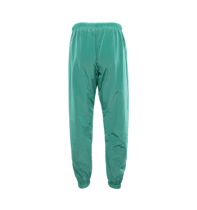 Image 2 of 4 - GREEN - FEAR OF GOD ESSENTIALS Crinkle Nylon Trackpants featuring an encased elastic waistband with elongated drawstrings, side seam pockets, an elastic hem with zipper adjustability at the ankle and a rubberized label at the center front. 100% nylon.  