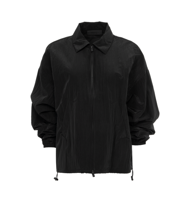 Image 1 of 2 - BLACK - FEAR OF GOD ESSENTIALS Shell Bomber featuring a cropped and rounded silhouette, a classic shirt collar, a rubber brand label at the upper back, a full zipper front closure, and a toggle bungee elastic hem for a customizable fit. 86% woven nylon, 14% spandex.
