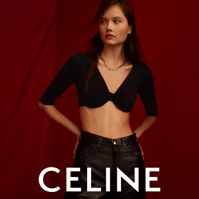 Woman wearing black draped crop top and black leather pants by Celine 