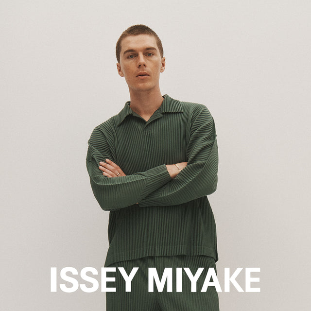 Man wearing Issey Miyake pleated shirt and pants in moss green 