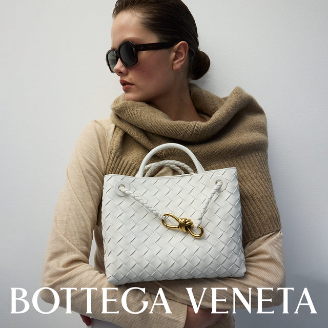 woman carrying BOTTEGA VENETA Small Andiamo handbag in white woven leather featuring leather top handle 