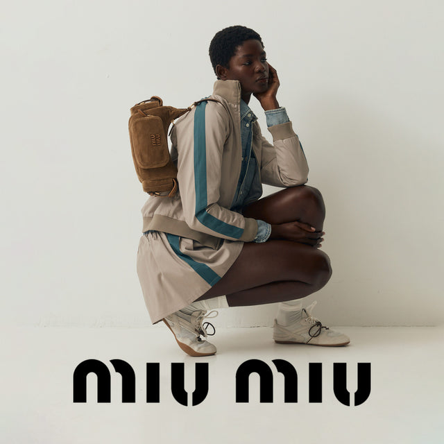 Person wearing Miu Miu beige and blue outfit with a brown bag 
