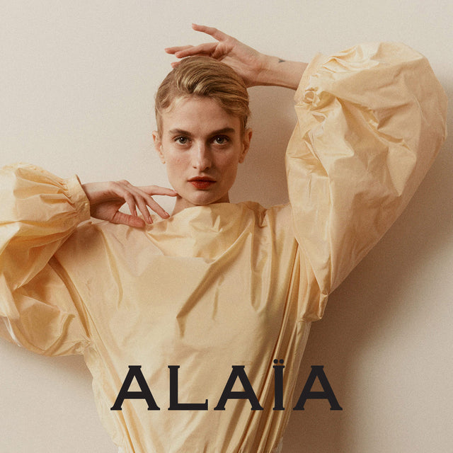 woman wearing cream-colored Alaia jumpsuit with voluminous sleeves 
