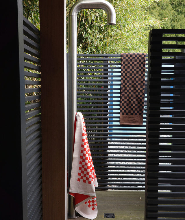 outdoor shower with 2 towels from BAINA The Heritage Towel Set - red and white checkerboard and brown and black checkerboard