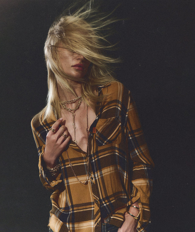 A blonde model with windblown hair wears Hoorsenbuhs layered gold necklaces, rings and bracelets. 