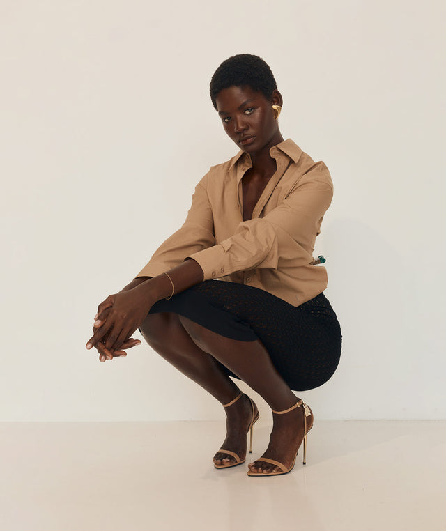 Woman in a beige shirt and black pencil skirt by Saint Laurent 