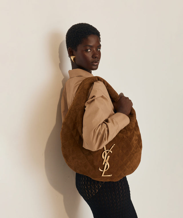 Woman holding a brown Icare handbag with YSL logo  