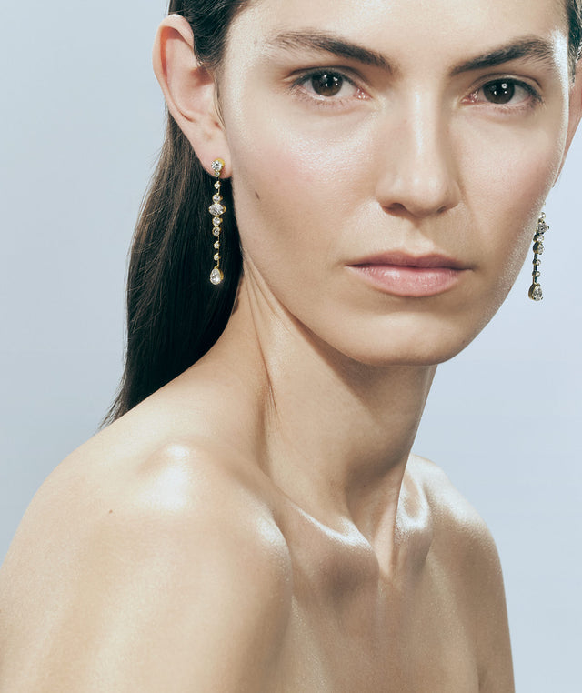 Woman wearing SOPHIE BILLE BRAHE Starry Earrings in yellow gold and white diamonds 