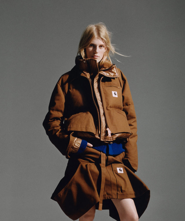 Person wearing a brownsacai x carhartt wip duck puffer jacket and canvas skort 