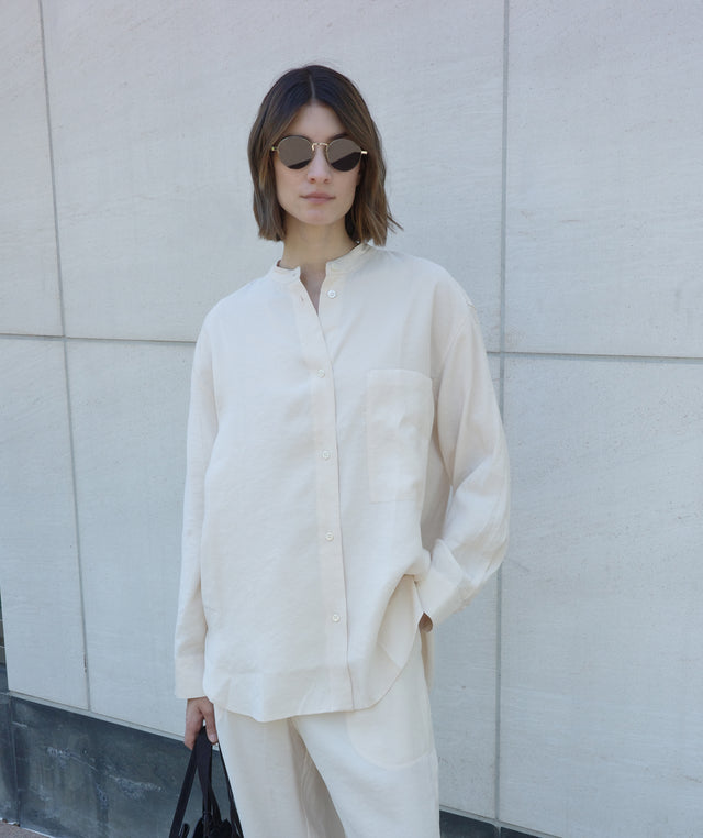 Woman wearing a cream-colored outfit by Studio Nicholson 