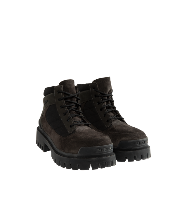 Image 2 of 4 - BROWN - Balenciaga Men's Combat Strike Low Boot is crafted from nubuck calfskin, suede calfskin, and cotton canvas and features an extra-round toe, a six-eyelet lace-up vamp, visible topstitching, and a worn-effect finish. Designed with a thick toothed rubber outsole, this low-profile combat boot is finished with Balenciaga logo detailing at the exterior, front, and back. Main Material: Calfskin leathers and Sole: TPU, Polyurethane. Heel Height: 20 mm / 0.8 in. Made in Italy. 