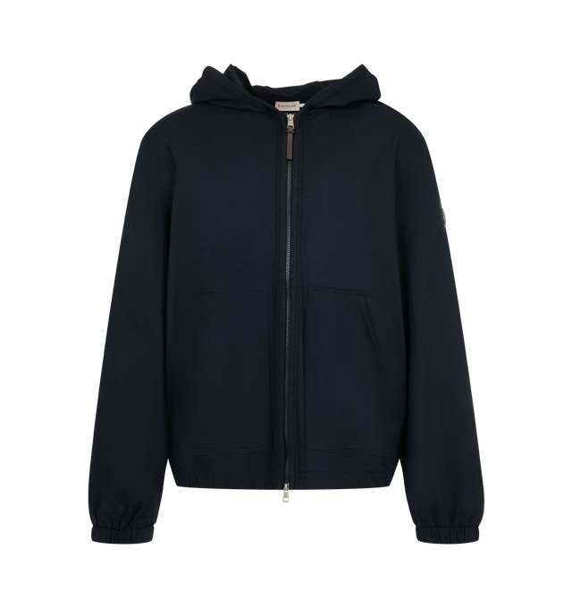 Image 1 of 1 - NAVY - Moncler Men's Zip-Up Hoodie Cardigan is crafted from a wool and polyester blend with a soft flannel-effect knit texture and features a loose-fit silhouette, an adjustable hood, and a front zip closure. Designed with front pockets, elasticated cuffs and hem, and a signature leather logo patch, this everyday layer combines comfort with refined casual styling. Main Material: 52% Polyester, 43% Wool, 5% Elastane. Hood: 52% Polyester, 43% Wool, 5% Elastane.  