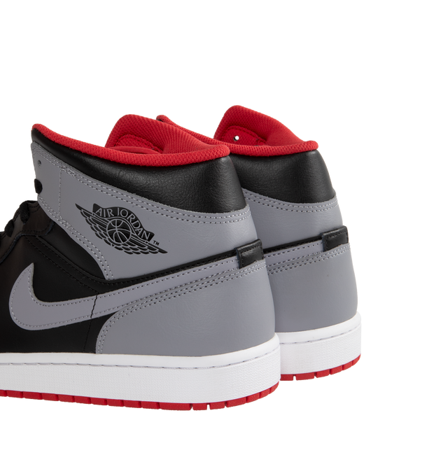 Image 3 of 5 - MULTI - AIR JORDAN 1 MID are grey, black and red sneakers made from a premium leather and synthetic upper which provides durability, comfort and support. These sneakers have an air-sole unit in the heel that delivers signature cushioning as well as has a rubber outsole that offers traction on a variety of surfaces. 