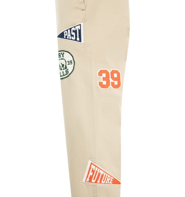 Image 3 of 4 - NEUTRAL - HUMAN MADE College Pants featuring high-density cotton chino cloth, relaxed silhouette, zip fly, brand message printed inside the back waist, bear label above one back pocket, heart button on the other, two side and back pockets and double roll-up cuff. 100% cotton. Made in Japan. 