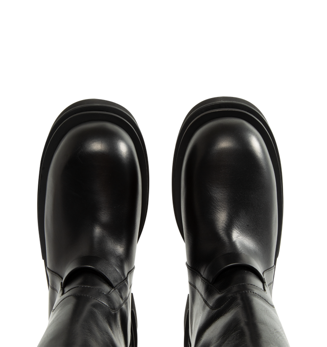 Image 4 of 4 - BLACK - Rick Owens Men's Naska Bogun Boots are crafted from washed calf leather and feature an under-the-knee silhouette with a wide shaft, a snap-fastening strap at the top, rounded toes, a geometric heel counter, and a Bogun rubber mega creeper sole with a toothed square heel. Main Material: 100% Calf Leather. Lining: 100% Calf Leather. Insole: 100% Calf Leather. Height: Under the Knee. Made in Italy. 