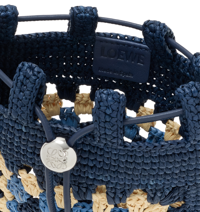 Image 4 of 4 - NAVY - LOEWE PAULA'S IBIZA Drawstring pocket in classic calfskin and raffia featuring a classic calfskin strap adjustable via an Anagram Pebble dice and a contrast LOEWE embroidery, shoulder or crossbody carry, unlined and engraved Anagram. Raffia/calf. 21 cm x  16 cm x 1 cm. Made in Spain. 
