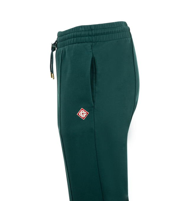 Image 3 of 3 - GREEN - Casablanca Embroidered CC Patch Open Hem Joggers have an elastic drawstring waist, a signature logo patch, side pockets, and a rear patch pocket. 100% cotton.  