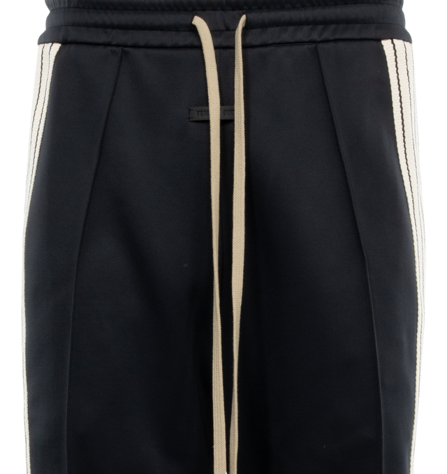 Image 3 of 3 - BLACK - FEAR OF GOD Stripe Relaxed Sweatpant featuring a relaxed fit with a pintuck stitch to shape the leg and a sports-inspired canvas side stripe, pockets, encased elastic waistband, elongated drawstrings and Fear of God leather label at the center front. 60% nylon, 40% cotton. 