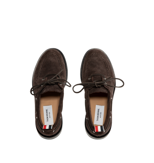 Image 4 of 4 - BROWN - Thom Browne Mens Boat Shoes are crafted from supple calf suede. Feature a lace-up closure, classic boat shoe silhouette, brogue detailing, rubber sole, and signature striped grosgrain loop tab. Main Material: Upper: 100% Calf Suede Leather; Lining: 100% Calf Leather; Sole: 100% Rubber. Made in Italy. 