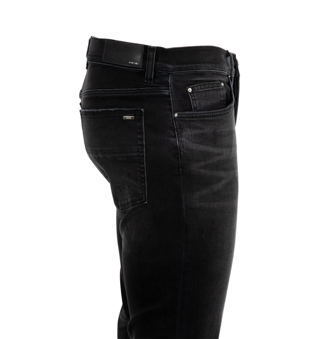 Image 3 of 3 - BLACK - Amiri MX1 Skinny Jeans are a 5-pocket style with a button and zip fly, distressing and rips overall, and a fitted silhouette with skinny legs. Polyester and elastane.  