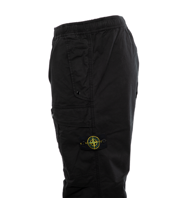 Image 3 of 4 - BLACK - STONE ISLAND Loose-Fit Cargo Pants featuring slanting hand pockets with slanted shaped flap and snap fastening, one patch bellows pocket on the back with shaped flap fixed on one side with a snap on the other side, big patch bellows pocket on the left leg, fixed on one side, snap on the other side, Stone Island badge, elasticized leg bottom and elasticized waistband with inner drawstring. 97% cotton, 3% elastane/spandex. 