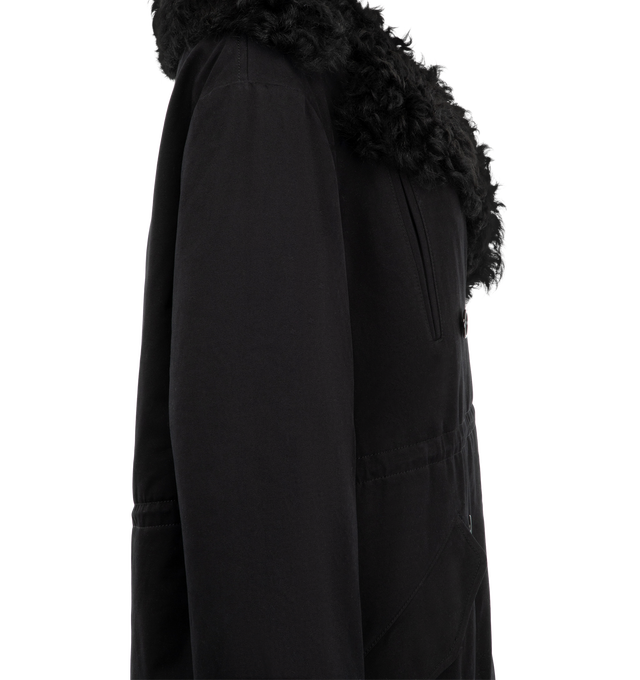 Image 3 of 3 - BLACK - Toteme Women's Shearling Cotton Parka that reimagines a heritage winter silhouette with a curly black shearling lining for exceptional warmth. Crafted from cotton with quilted sleeves, it features adjustable drawstrings at the waist and hem for a customizable fit, plus four pockets for practicality. Materials: 100% organic cotton; lining: 100% lamb leather; sleeve lining: 100% viscose. 