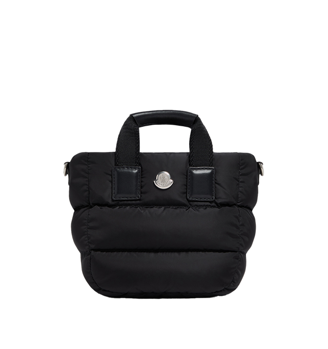 Image 1 of 1 - BLACK - Moncler Women's Micro Caradoc Tote Bag is crafted from quilted nylon and features the brand's signature down-filled construction, ribbon top handles with leather grips, and an adjustable, detachable leather shoulder strap. Inspired by Moncler's iconic puffer jackets, this compact tote is designed for on-the-go use and is finished with a top zip closure and a leather logo patch. Main Material: 100% Polyamide / Nylon. Lining: 100% Cotton. Padding: 90% Down, 10% Feather. Trim: Calf Leath 