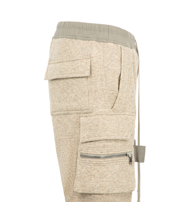 Image 3 of 3 - NEUTRAL - Rick Owens Men's Mastodon Cargo Pants are crafted from a wool and cotton blend and feature a slim cargo silhouette with an elasticized drawstring waistband. Designed with a concealed fly and button closure, the style is finished with cargo pockets on both sides for a utilitarian look. Main Material: 65% wool, 35% cotton. 