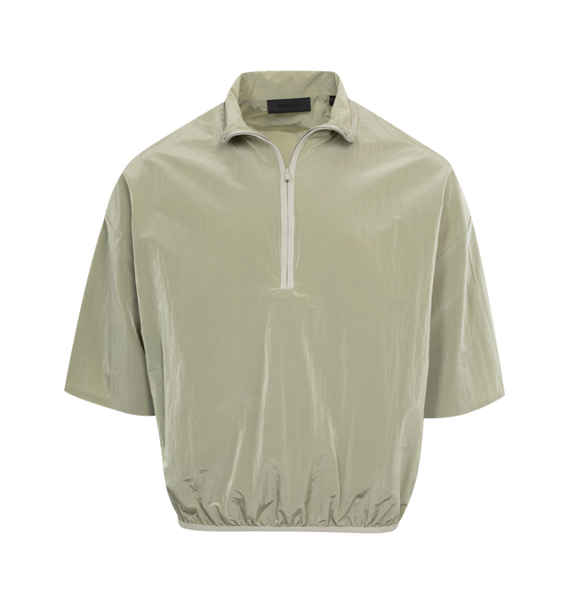 Image 1 of 2 - GREEN - FEAR OF GOD ESSENTIALS Halfzip Mockneck Shirt featuring short-sleeves, round, cropped silhouette, stretch binding at the mock neckline and waist hem, rubberized Essentials Fear of God black bar on the sleeve and a Fear of God rubberized label at the back collar. 100% nylon.  