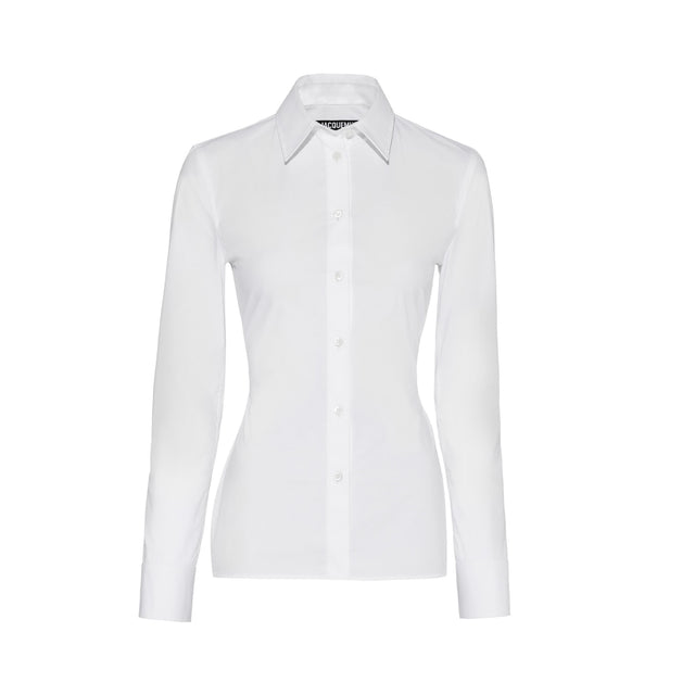 Image 1 of 3 - WHITE - JACQUEMUS Open Back Shirt featuring fitted shape, cotton poplin, pointed collar, asymmetric J shaped chest pocket, buttoned cuffs, J locker loop, back yoke, triangular open back, integrated buckled belt and metal ring and studs. 100% cotton. Made in Bulgaria. 