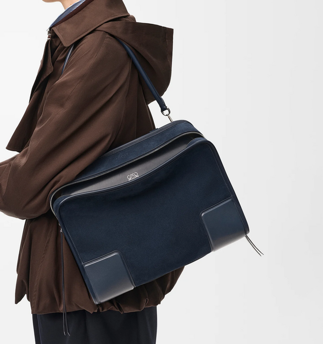 Image 2 of 16 - NAVY - Loewe Large Amazona 180 Bag in suede featuring a relaxed silhouette anchored by a single toron top handle, designed to be carried open while a concealed closure secures the main compartment, removable shoulder and crossbody straps, zip closure with two leather zip pullers, two compartments, main compartment closed with magnetic closure, internal flat pocket, left side d-ring for customization, suede and nappa lambskin lining, embossed LOEWE and embossed double L branding. Suede/calf.  