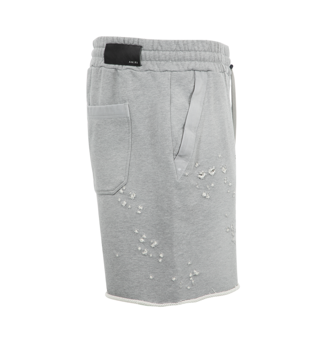 Image 3 of 3 - GREY - Amiri MA Shotgun Embroidered Shorts have an elastic drawstring waist, a distressed effect, raw edges, side zip pockets, a rear patch pocket, and an embroidered logo at the front.  