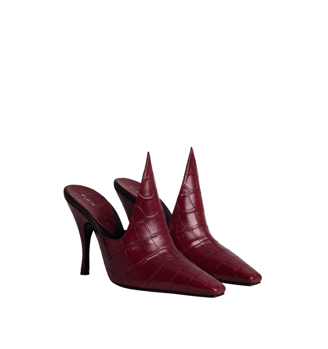Image 1 of 1 - RED - Alaa women's Croco Mules are crafted from shiny crocodile-effect embossed calfskin leather. The elegant design features a squared pointed toe, a sculptural spike detail, and a leather-wrapped 100 mm stiletto heel for a striking, modern silhouette. Heel height: 100 mm. Upper material: 100% calf leather. Main lining: 100% lamb leather. Outer sole: 50% calf leather, 50% rubber. Made in Italy. 