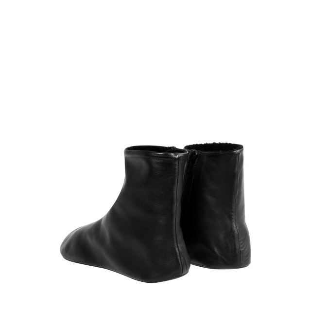 Image 3 of 4 - BLACK - THE ROW Stella Boot featuring minimal ankle boot in smooth nappa leather with inner side zip closure, soft shearling lining and flexible rubber-coated sole. 100% lambskin leather. Synthetic sole. Made in Italy. 