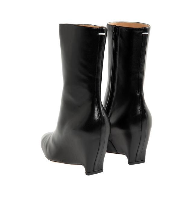 Image 3 of 4 - BLACK - Maison Margiela Women's Heel-Less Ankle Boots are crafted from soft nappa leather and reinterpret the Maison's archival heel-less silhouette with a sleek pointed toe and sculptural wedge heel. The seamless upper rises into an 80mm wedge, while the signature single white stitch at the back provides an understated house detail. Upper: 100% Ovine Leather. Lining: 100% Ovine Leather. Inside: 100% Ovine Leather. Sole: 100% Calf Leather. Heel Height: 80 mm / 3.1 in. Made in Italy. 