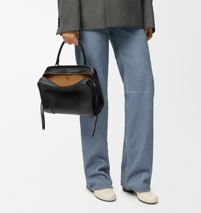Image 3 of 17 - BLACK - Loewe Amazona Medium 180 Bag in soft calfskin leather featuring a relaxed silhouette with a single toron top handle, designed to be carried open, while a concealed closure secures the main compartment, removable shoulder and crossbody straps, zip closure with two leather zip pullers, two compartments, main compartment closed with magnetic closure, internal flat pocket, suede lining and embossed logo. Soft calfskin. Strap length 108 cm; Strap Drop 50 cm; Handle drop 11 - 28 cm; Height 