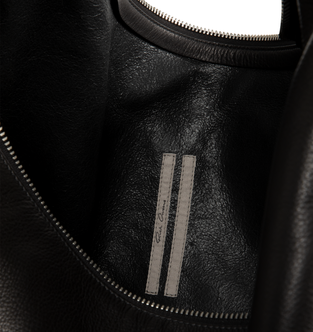 Image 3 of 3 - BLACK - Rick Owens Gemini Bag is crafted from glossy butter calf leather and features a large, soft A-shaped silhouette with a slouched center and curved shoulder strap. Designed with a top zip closure, Gemini double-ended snap hook engraved with the Rick Owens logo, an interior pouch pocket, and an exterior flat pocket with signature U-shaped stitching detail. Main Material: 100% Calf Leather. Dimensions: 54 cm x 38 cm x 12 cm. Fits: 13"16" laptop, documents, tablet, wallet, phone, water b 