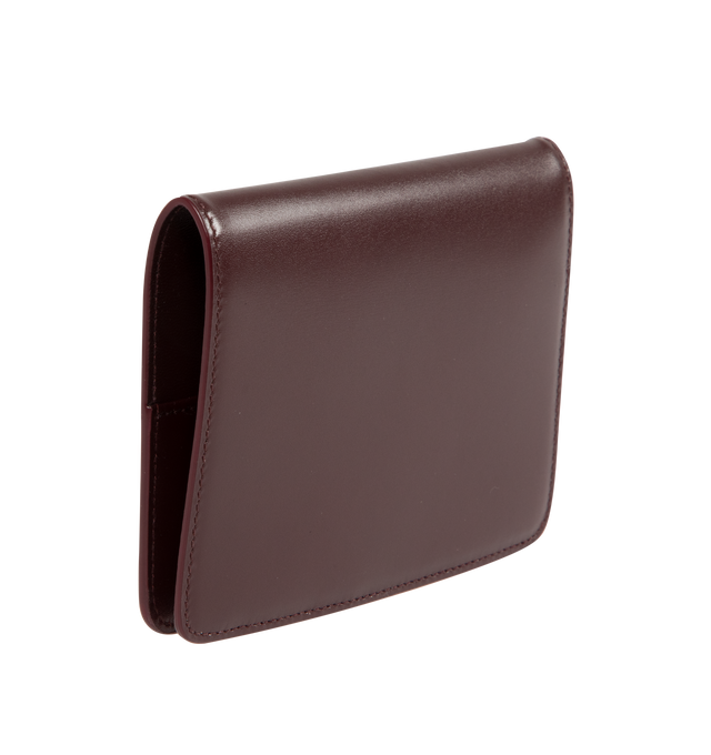 Image 2 of 3 - RED - Saint Laurent VOLTAIRE passport holder with inner card slots, decorated with the CASSANDRE. Featuring leather lining, bronze-toned hardware, two flat pockets, five card slots. Measures 5.3" x 3.9" x 0.8". Made in Italy. 