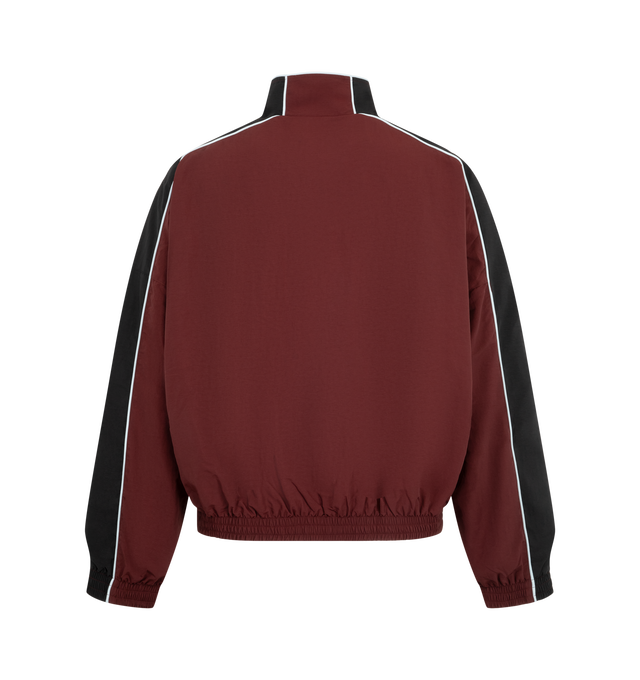 Image 2 of 3 - RED - Willy Chavarria Bad Boy Track Jacket is crafted from nylon and features a sleek, true-to-size silhouette defined by bold chevron paneling and contrast piping. Designed with a stand collar, front zip closure, two zippered pockets, stacked script logo detailing, and elasticized cuffs and hem. Main Material: 100% Nylon. Lining: Polyester. 